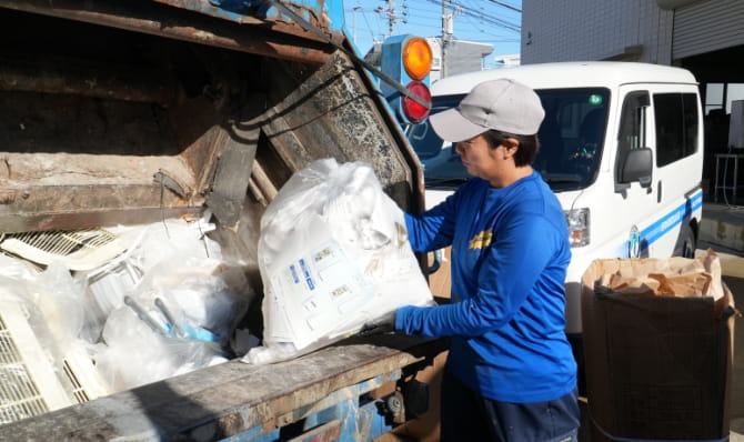 作業員がトラックに廃棄物を積み込む様子