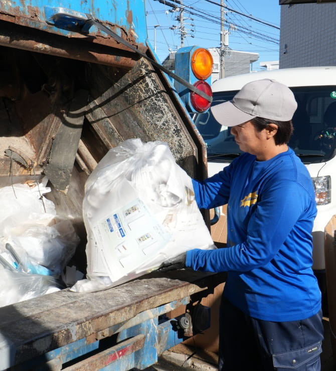 作業員がトラックに廃棄物を積み込む様子